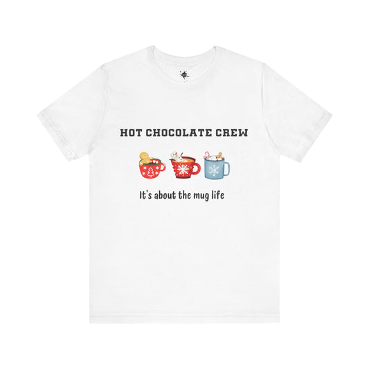 White t-shirt featuring three cups of hot chocolate and the phrase 'It's about the mug life,' perfect for cozy winter vibes and casual holiday style