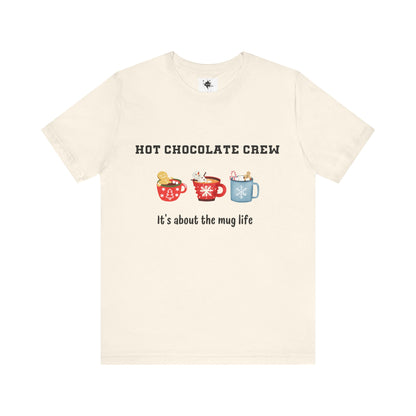 cream t-shirt featuring three cups of hot chocolate and the phrase 'It's about the mug life,' perfect for cozy winter vibes and casual holiday style